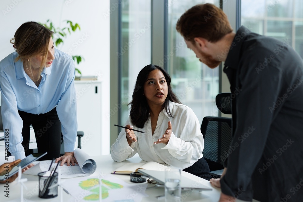 Three people talking to each other in a workplace